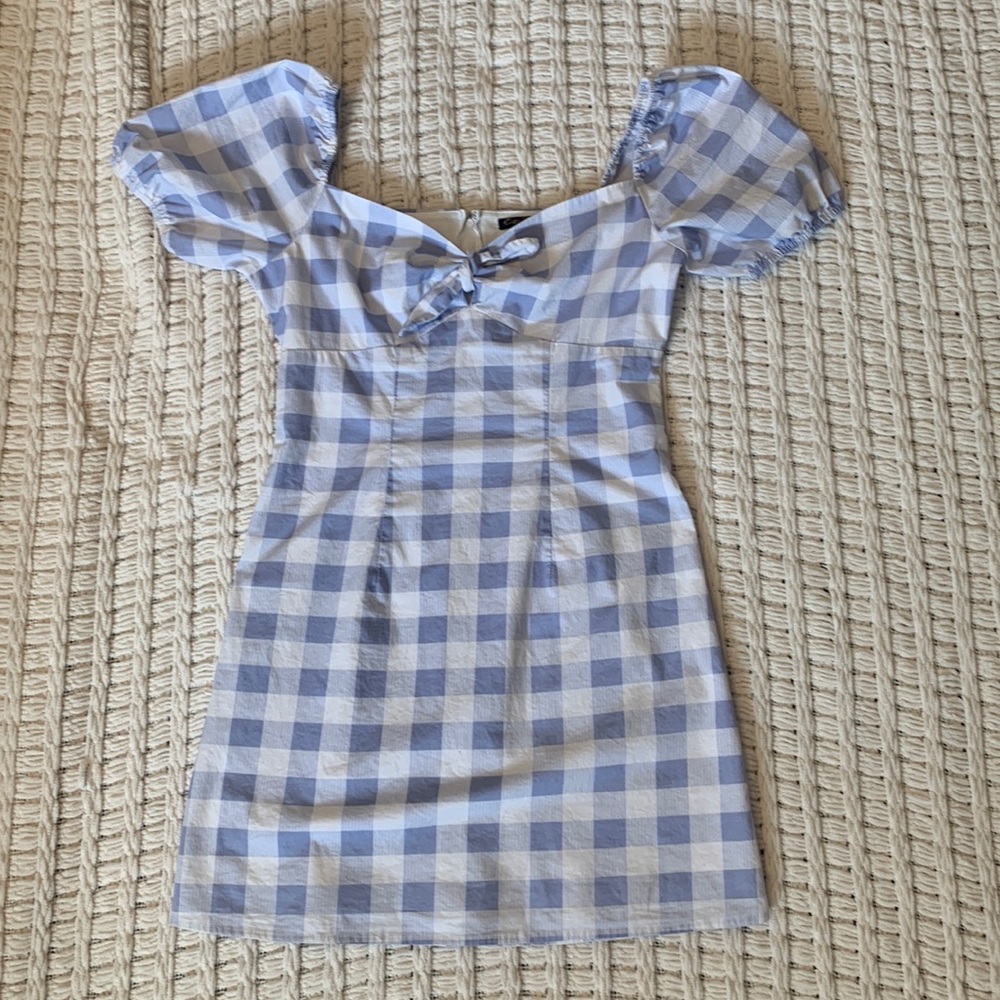 white and periwinkle checkered design. Tie top and puffy sleeves. Size small.